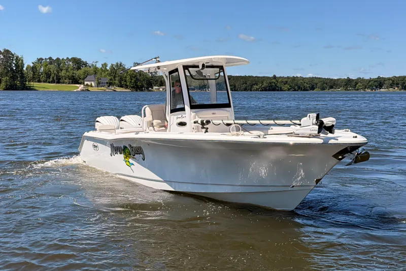 Slide: The Image of 2024 Sea Hunt Gamefish 27 Coffin Box boat cruising on a sunny lake. - 2