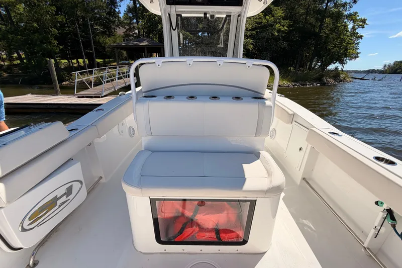 Slide: The Image of 2024 Sea Hunt Gamefish 27 Coffin Box boat interior with seating and storage, dockside view. - 21