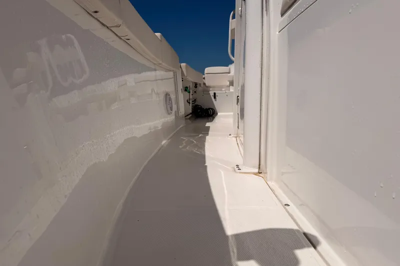 Slide: The Image of 2024 Sea Hunt Gamefish 27 Coffin Box boat deck, white interior, sunny day. - 26