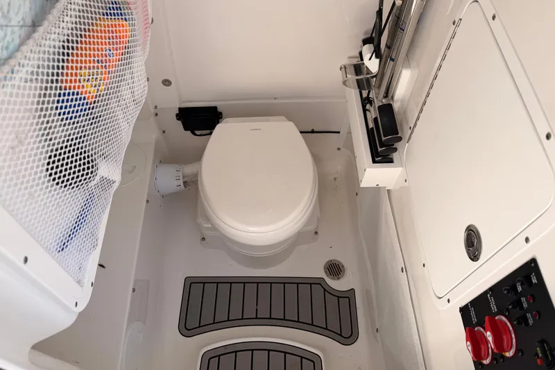 Slide: The Image of 2024 Sea Hunt Gamefish 27 Coffin Box boat interior with toilet and storage features. - 27