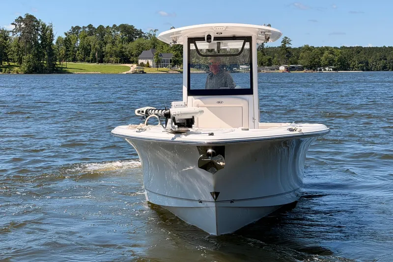 Slide: The Image of 2024 Sea Hunt Gamefish 27 Coffin Box boat cruising on a scenic lake. - 3