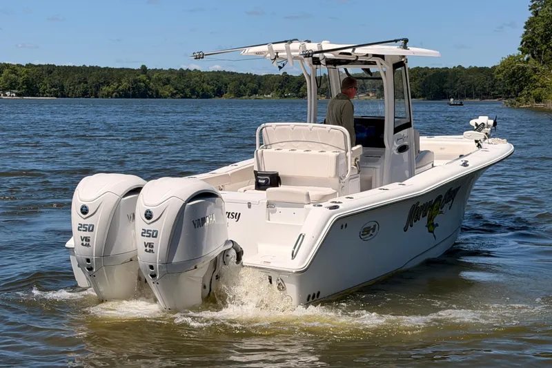 Slide: The Image of 2024 Sea Hunt Gamefish 27 Coffin Box boat with twin Yamaha 250 V6 engines on a lake. - 5