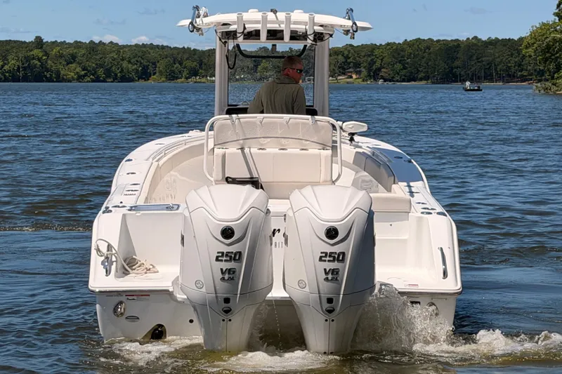Slide: The Image of 2024 Sea Hunt Gamefish 27 Coffin Box boat with dual 250 V6 engines on a lake. - 6