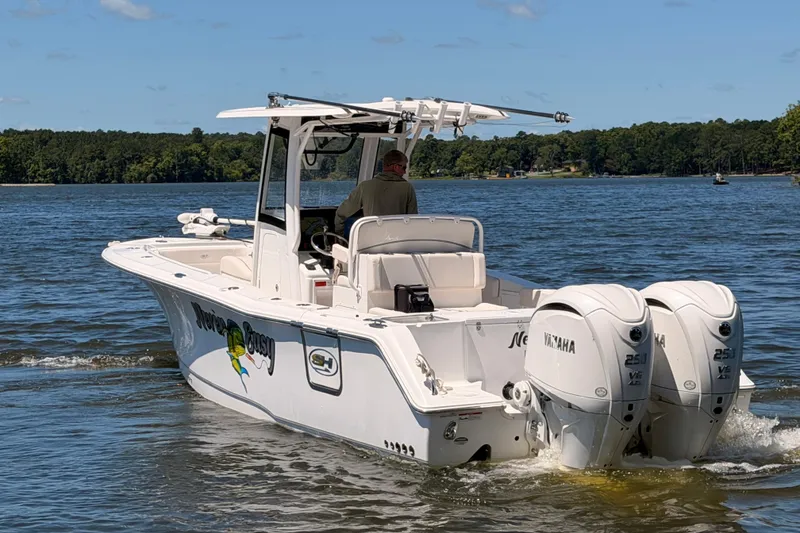 Slide: The Image of 2024 Sea Hunt Gamefish 27 Coffin Box boat cruising on a lake with twin Yamaha engines. - 7