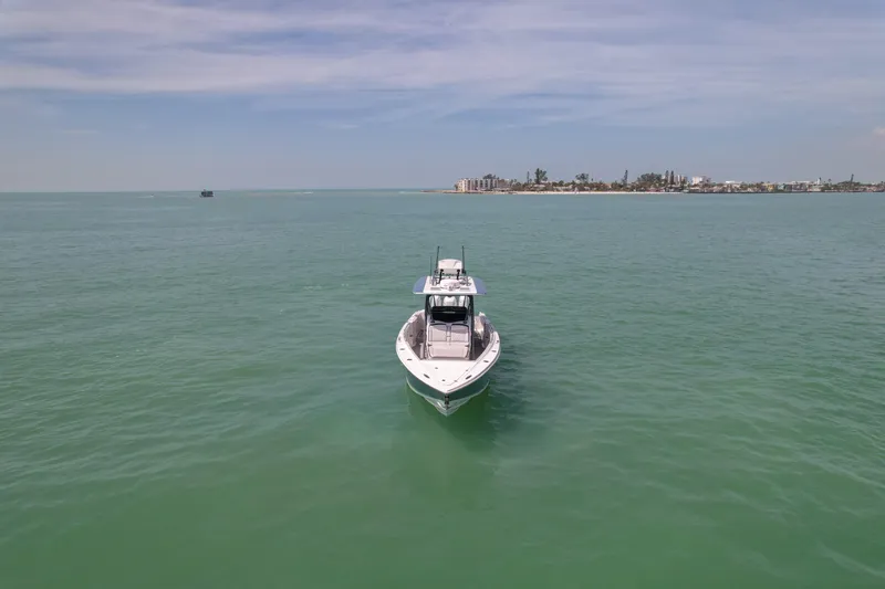 Slide: The Image of 2020 Nor-Tech 390 Sport Center Console on open water, distant shoreline visible. - 11
