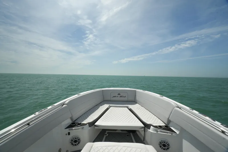 Slide: The Image of 2020 Nor-Tech 390 Sport Center Console boat on open sea under clear sky. - 14