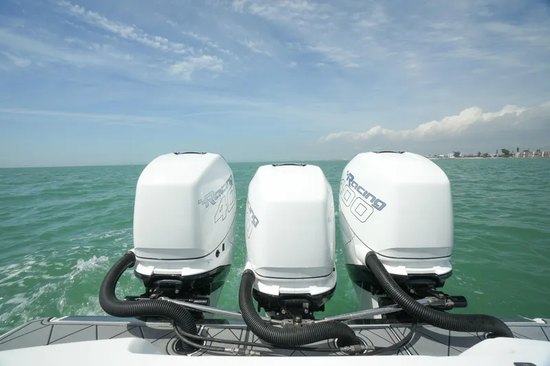 Slide: The Image of 2020 Nor-Tech 390 Sport Center Console with triple outboard engines on open water. - 19