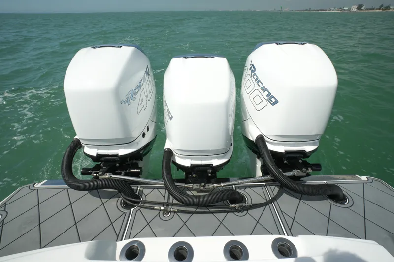 Slide: The Image of 2020 Nor-Tech 390 Sport Center Console with triple outboard engines on open water. - 20