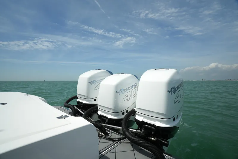 Slide: The Image of 2020 Nor-Tech 390 Sport Center Console with triple outboard engines on open water. - 21
