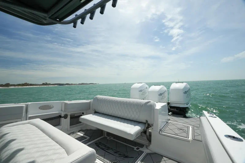 Slide: The Image of 2020 Nor-Tech 390 Sport Center Console on open water, featuring luxurious seating and triple engines. - 24