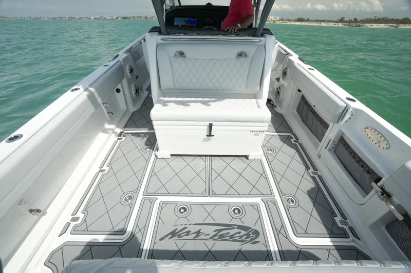 Slide: The Image of 2020 Nor-Tech 390 Sport Center Console boat interior on calm turquoise water. - 27