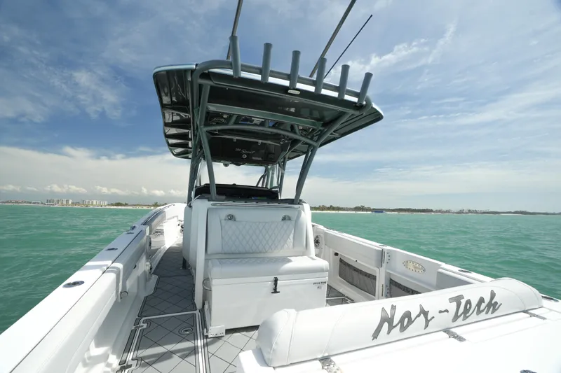 Slide: The Image of 2020 Nor-Tech 390 Sport Center Console boat on open water, showcasing sleek design and spacious deck. - 28