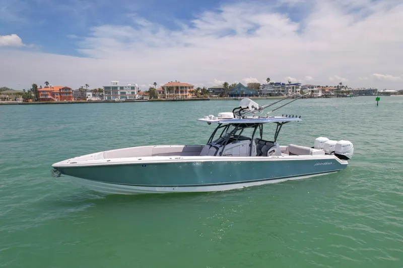 Slide: The Image of 2020 Nor-Tech 390 Sport Center Console boat on calm water, with coastal homes in the background. - 3