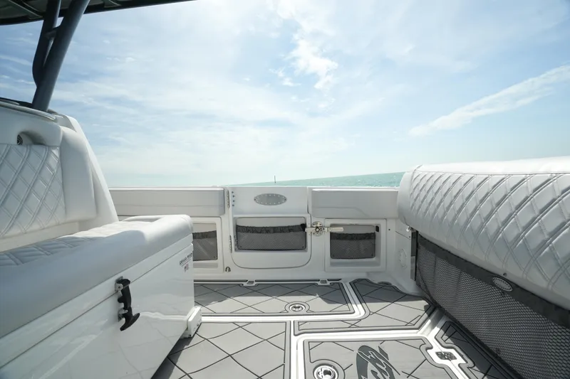 Slide: The Image of 2020 Nor-Tech 390 Sport Center Console interior with cushioned seating and ocean view. - 30