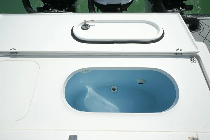 Slide: The Image of Livewell on 2020 Nor-Tech 390 Sport Center Console boat, open lid, blue interior. - 48