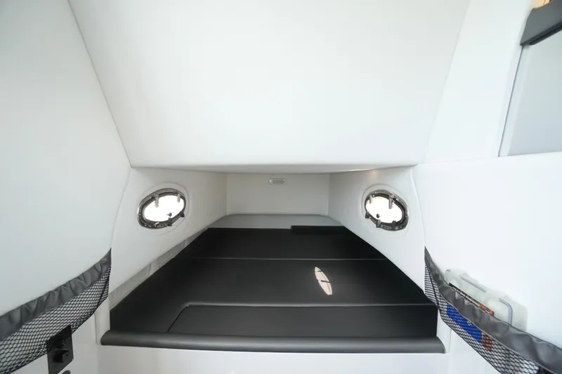 Slide: The Image of 2020 Nor-Tech 390 Sport Center Console cabin interior with sleek black seating and portholes. - 51
