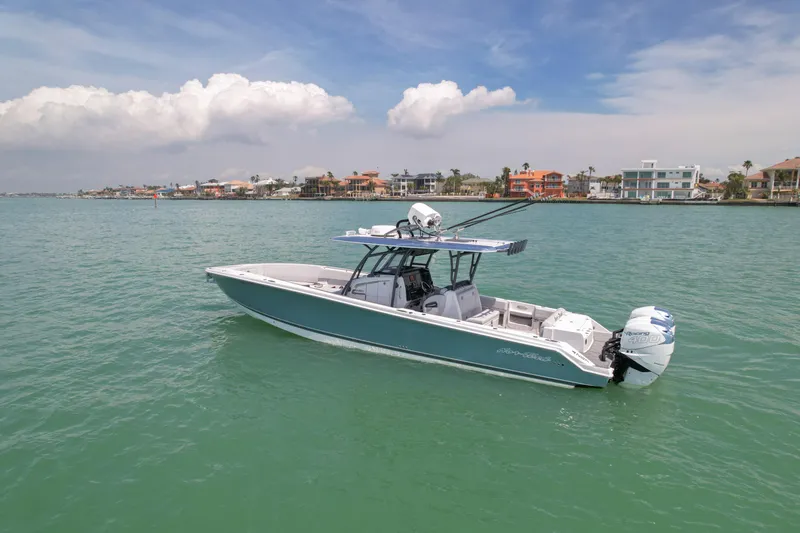 Slide: The Image of 2020 Nor-Tech 390 Sport Center Console boat on calm water, coastal homes in background. - 6