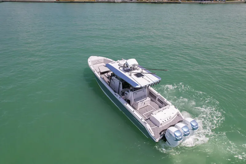 Slide: The Image of 2020 Nor-Tech 390 Sport Center Console boat cruising on clear turquoise water. - 7