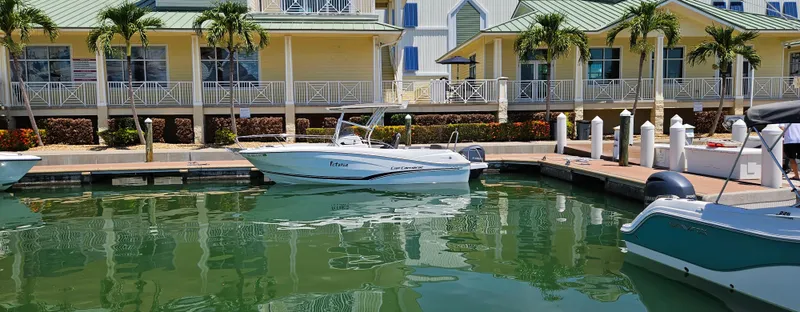 Slide: The Image of 2019 Jeanneau Leader 7.5 CC boat docked near colorful waterfront buildings. - 2
