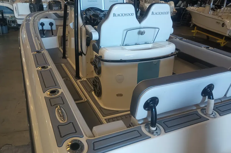 Slide: The Image of 2020 Blackwood 27 boat interior with seating and fishing rod holders. - 14