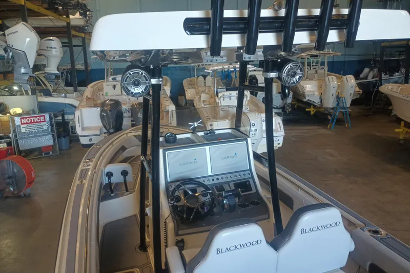 Slide: The Image of 2020 Blackwood 27 boat interior with Garmin navigation, in a showroom with other boats. - 15