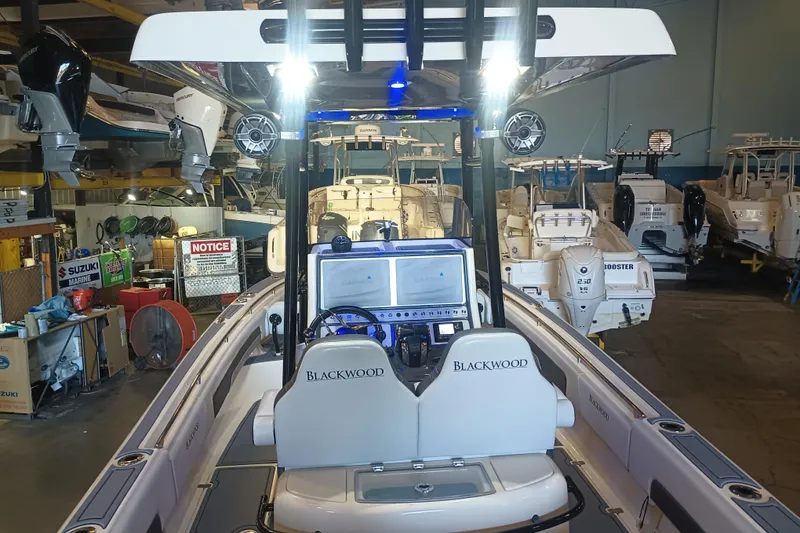 Slide: The Image of 2020 Blackwood 27 boat in a showroom with multiple marine engines. - 16