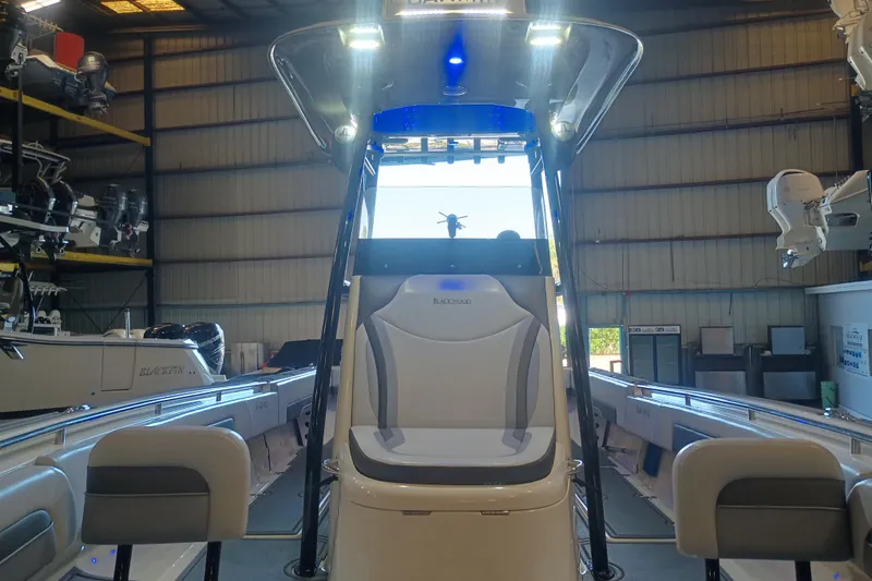 Slide: The Image of 2020 Blackwood 27 boat interior in a warehouse, showcasing seating and equipment. - 24