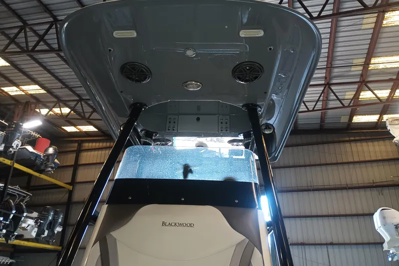 Slide: The Image of 2020 Blackwood 27 boat interior with speakers and console, inside a warehouse. - 26