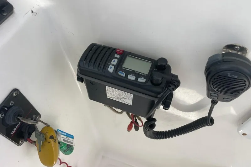 Slide: The Image of 2004 Sea Pro 238 Walk Around boat dashboard with Icom marine radio and Yamaha ignition key. - 11