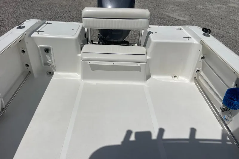 Slide: The Image of 2004 Sea Pro 238 Walk Around boat interior with seating and clean deck. - 19