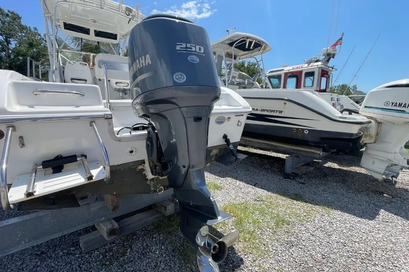 Slide: The Image of 2004 Sea Pro 238 Walk Around boat with Yamaha 250 engine, parked on gravel. - 2