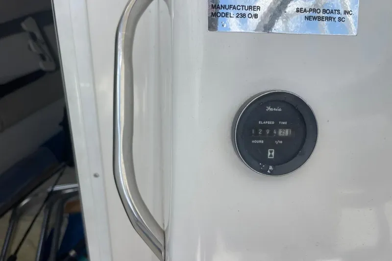 Slide: The Image of 2004 Sea Pro 238 Walk Around boat hour meter and manufacturer label. - 21