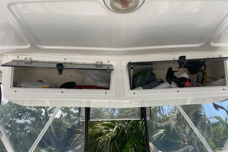Slide: The Image of 2004 Sea Pro 238 Walk Around boat storage compartments with various items inside. - 24
