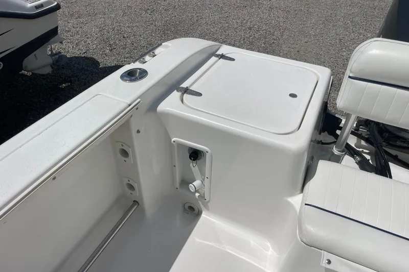 Slide: The Image of 2004 Sea Pro 238 Walk Around boat interior, featuring seating and storage compartments. - 25