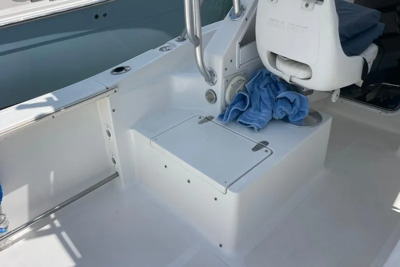 Slide: The Image of 2004 Sea Pro 238 Walk Around boat interior with seating and storage area. - 27