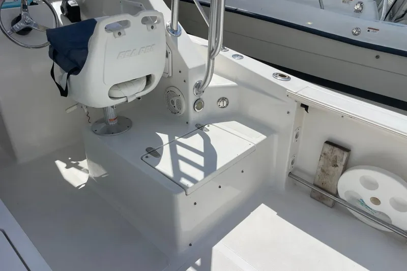 Slide: The Image of 2004 Sea Pro 238 Walk Around boat interior with helm seat and storage area. - 28