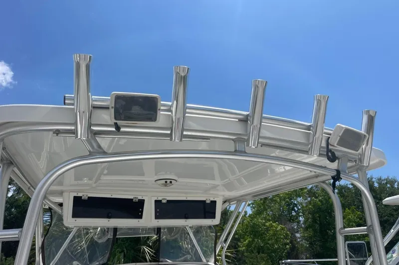 Slide: The Image of 2004 Sea Pro 238 Walk Around boat with rod holders and canopy under clear blue sky. - 29