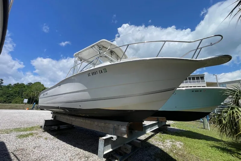 Slide: The Image of 2004 Sea Pro 238 Walk Around boat on trailer under blue sky. - 3