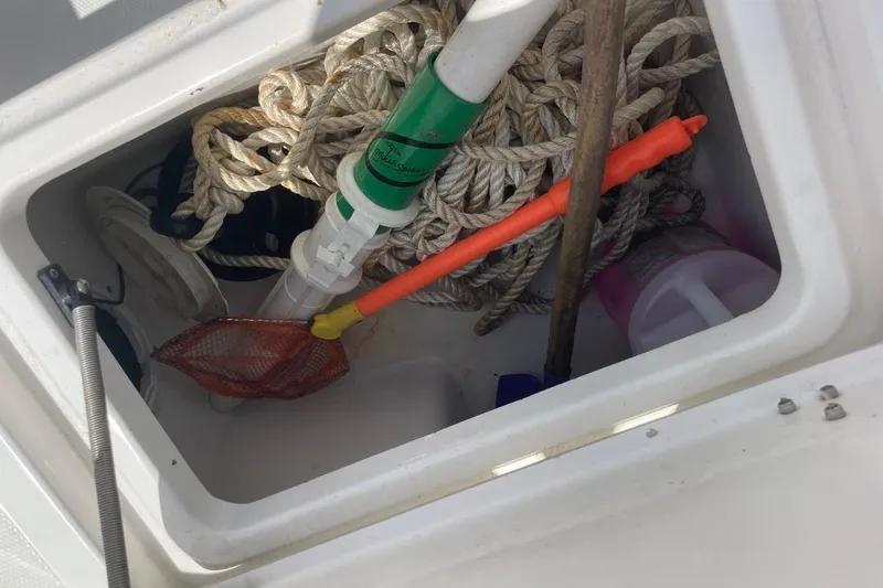 Slide: The Image of Storage compartment on a 2004 Sea Pro 238 Walk Around boat with ropes and tools. - 31