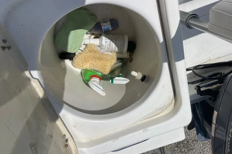 Slide: The Image of Storage compartment on 2004 Sea Pro 238 Walk Around boat with cleaning supplies. - 34