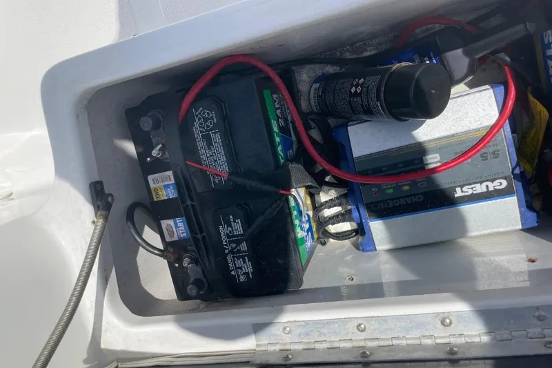 Slide: The Image of Battery compartment of a 2004 Sea Pro 238 Walk Around boat with charger and cables. - 37