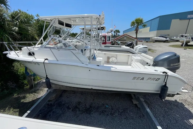 Slide: The Image of 2004 Sea Pro 238 Walk Around boat on trailer, featuring Yamaha engines, in a marina setting. - 6
