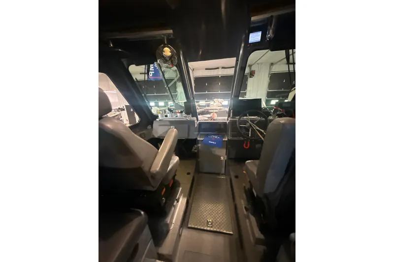 Slide: The Image of Interior view of 2022 Hewescraft 270 Alaskan Hardtop boat cockpit with seating and controls. - 12