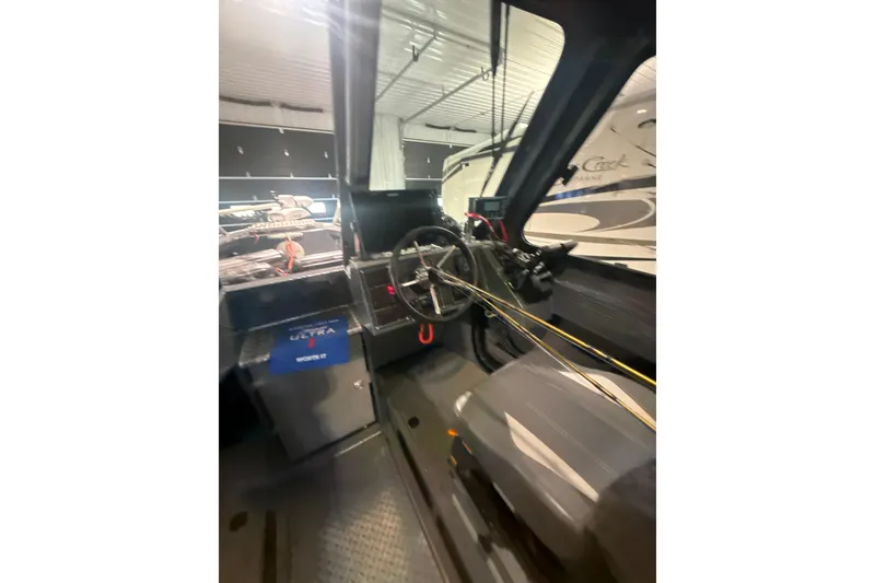 Slide: The Image of Interior view of 2022 Hewescraft 270 Alaskan Hardtop boat, showcasing steering wheel and controls. - 14