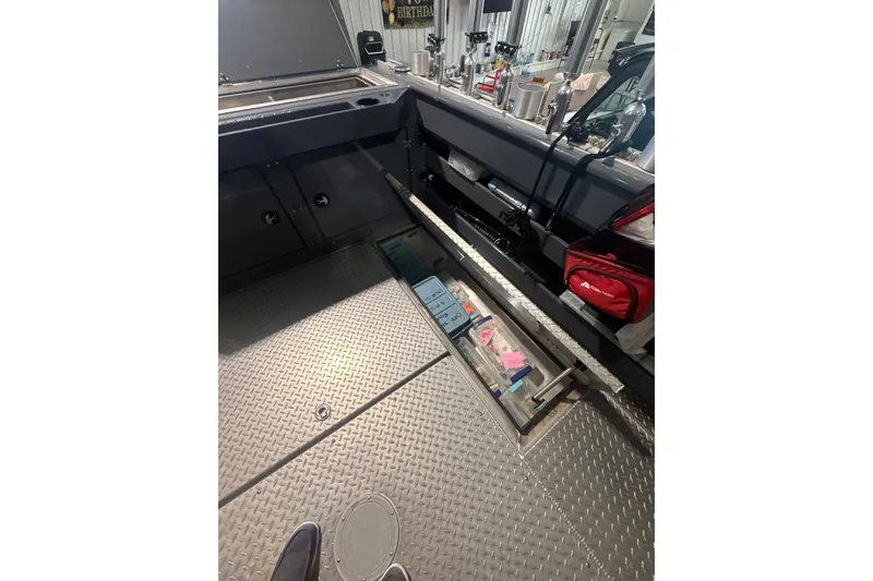 Slide: The Image of Interior view of 2022 Hewescraft 270 Alaskan Hardtop with storage compartments and equipment. - 17