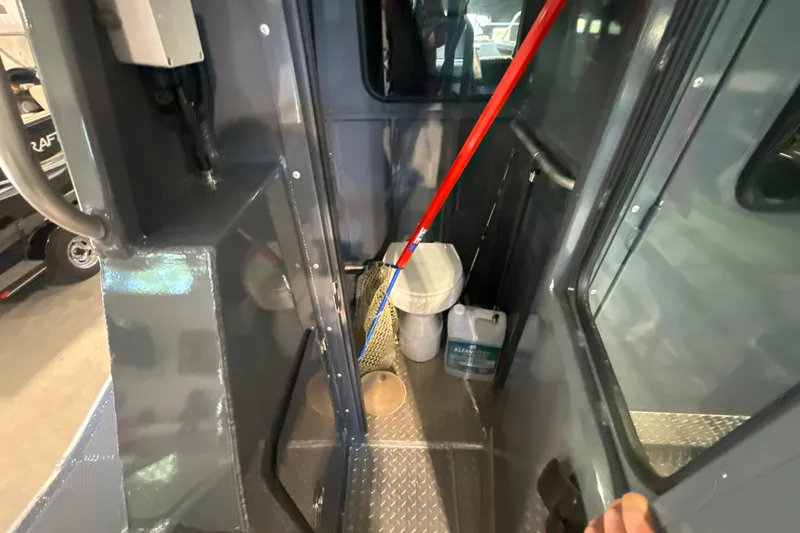 Slide: The Image of Interior of 2022 Hewescraft 270 Alaskan Hardtop, featuring storage area and cleaning supplies. - 23