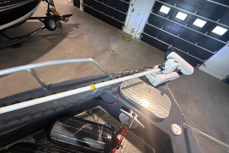 Slide: The Image of 2022 Hewescraft 270 Alaskan Hardtop boat with mounted trolling motor in garage. - 24