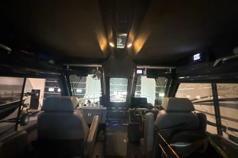 Slide: The Image of Interior view of 2022 Hewescraft 270 Alaskan Hardtop boat, showcasing seating and dashboard. - 25