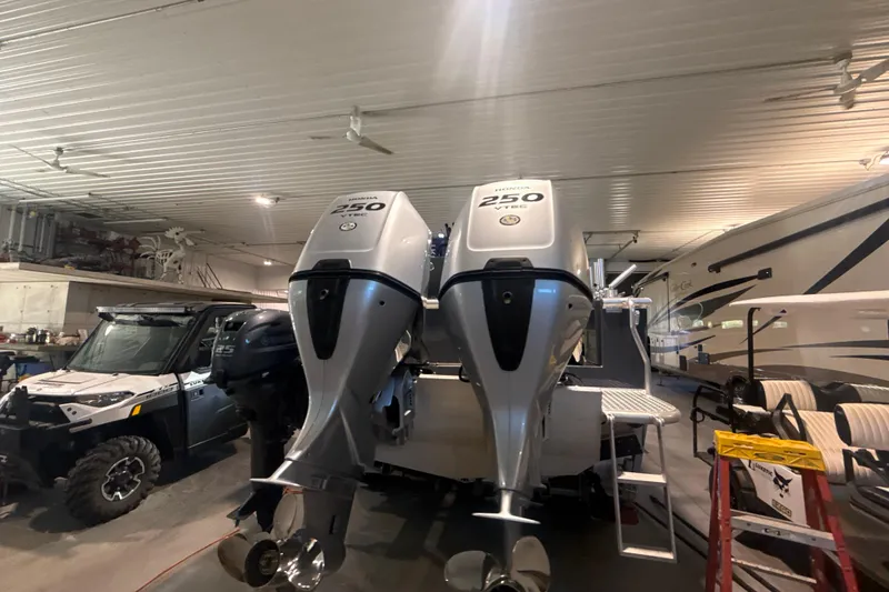 Slide: The Image of 2022 Hewescraft 270 Alaskan Hardtop with dual Honda 250 outboard engines in a garage. - 27