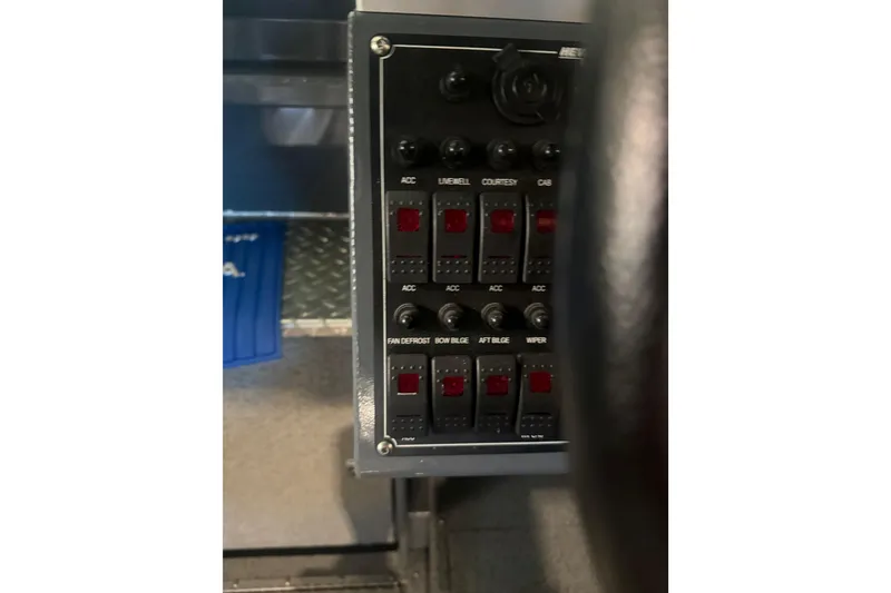 Slide: The Image of Control panel of a 2022 Hewescraft 270 Alaskan Hardtop boat, featuring various switches. - 29